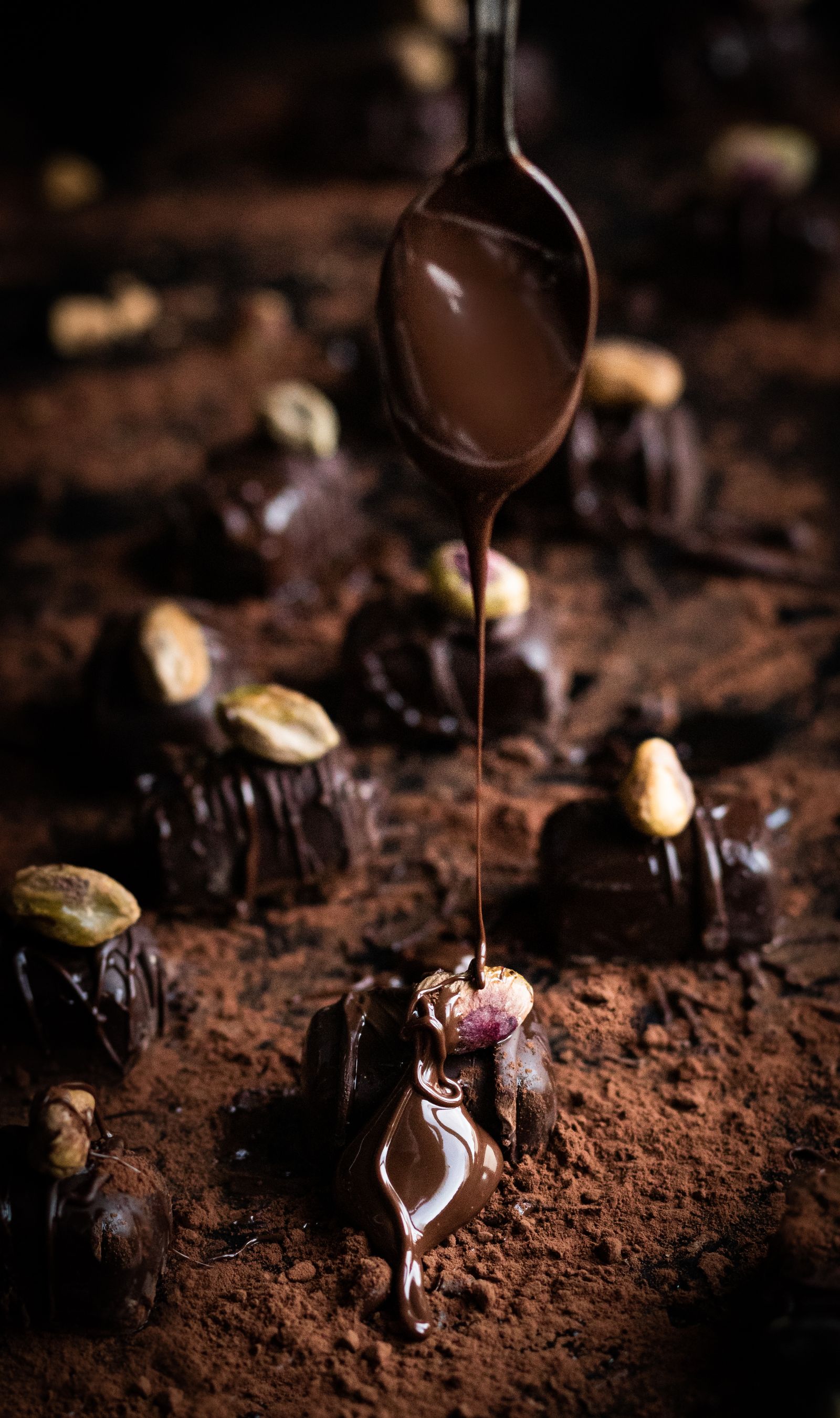 Chocolate is drizzled over pistachio-topped artisan confections