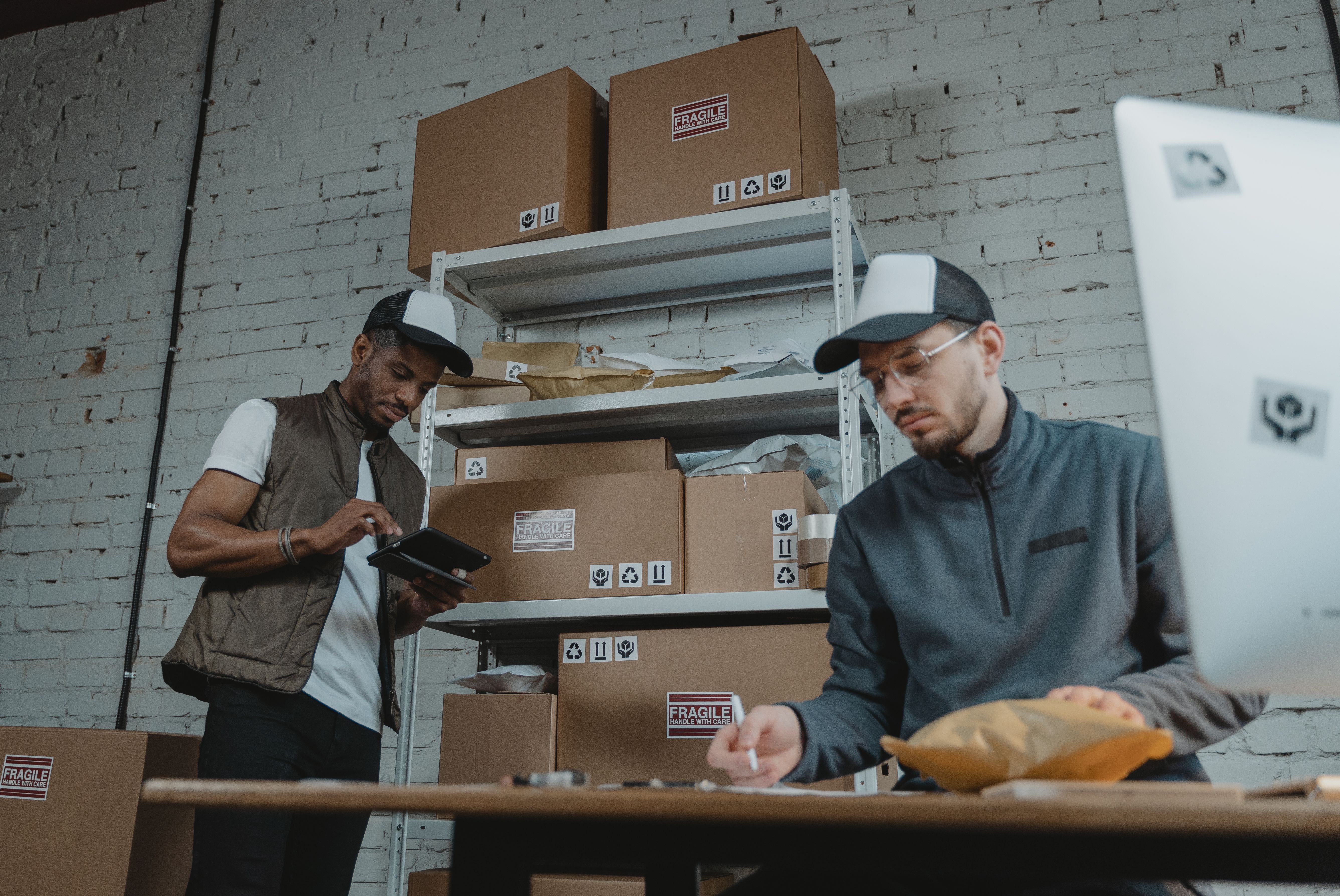 Two warehouse workers organizing cardboard parcels for shipment