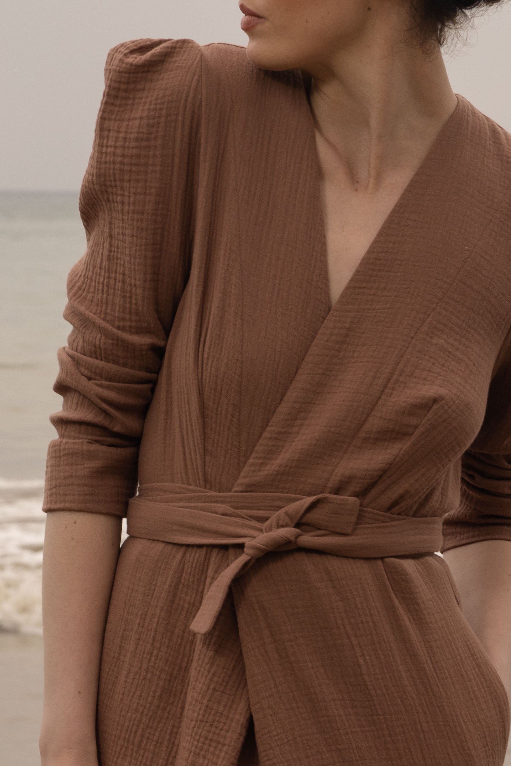 Model wearing a brown wrap-style Milan dress by Heidi Merrick