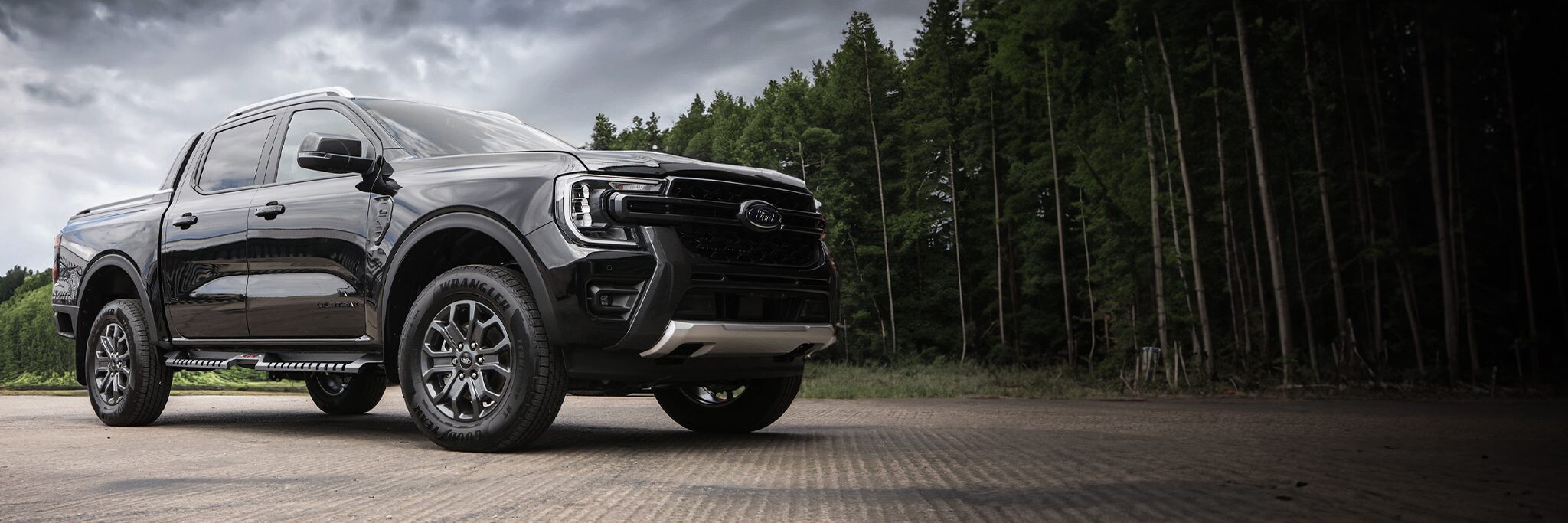 Dark grey pickup truck fitted with off-road wheels and accessories