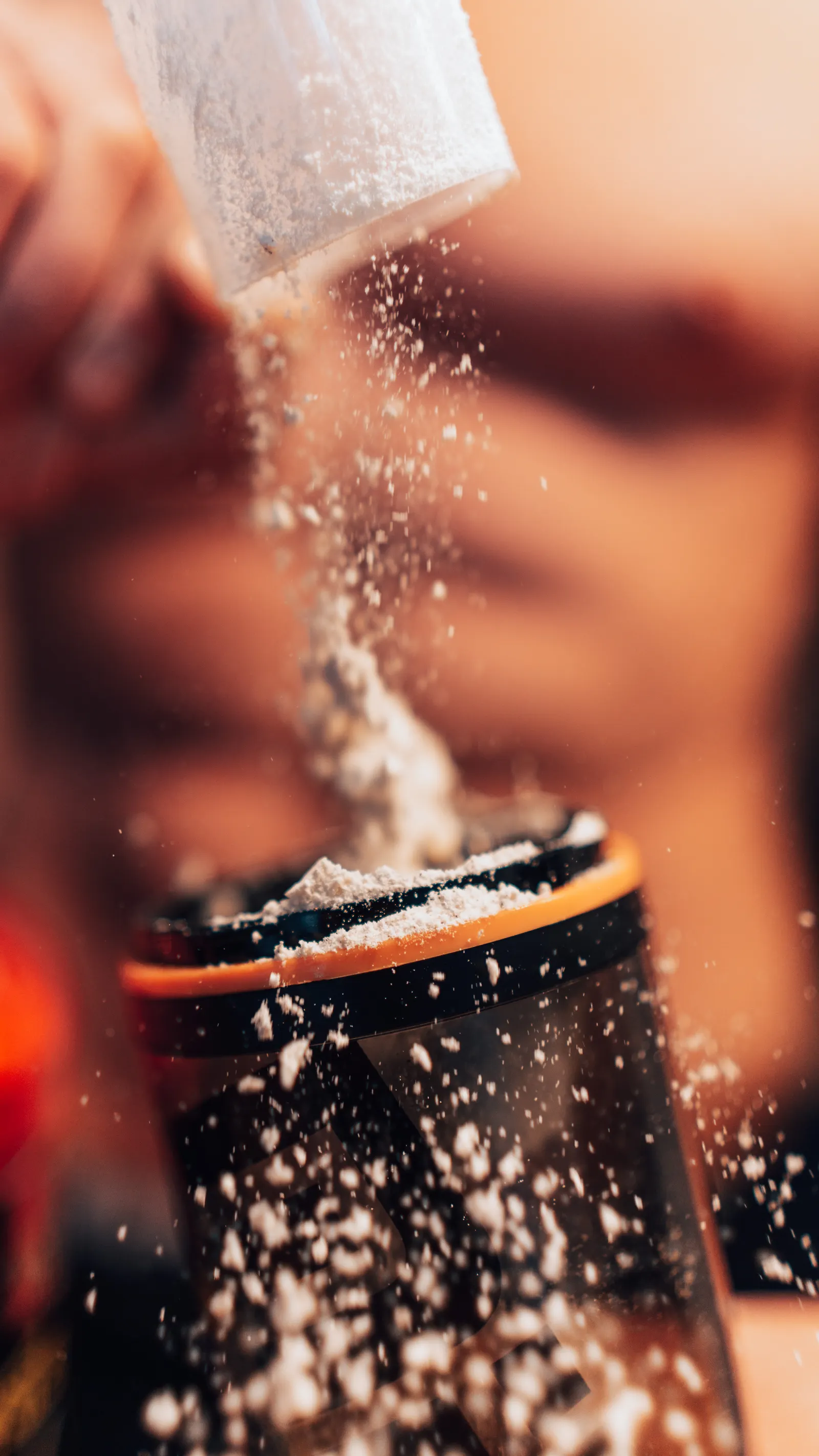 Protein powder being added to a shaker for a fitness drink