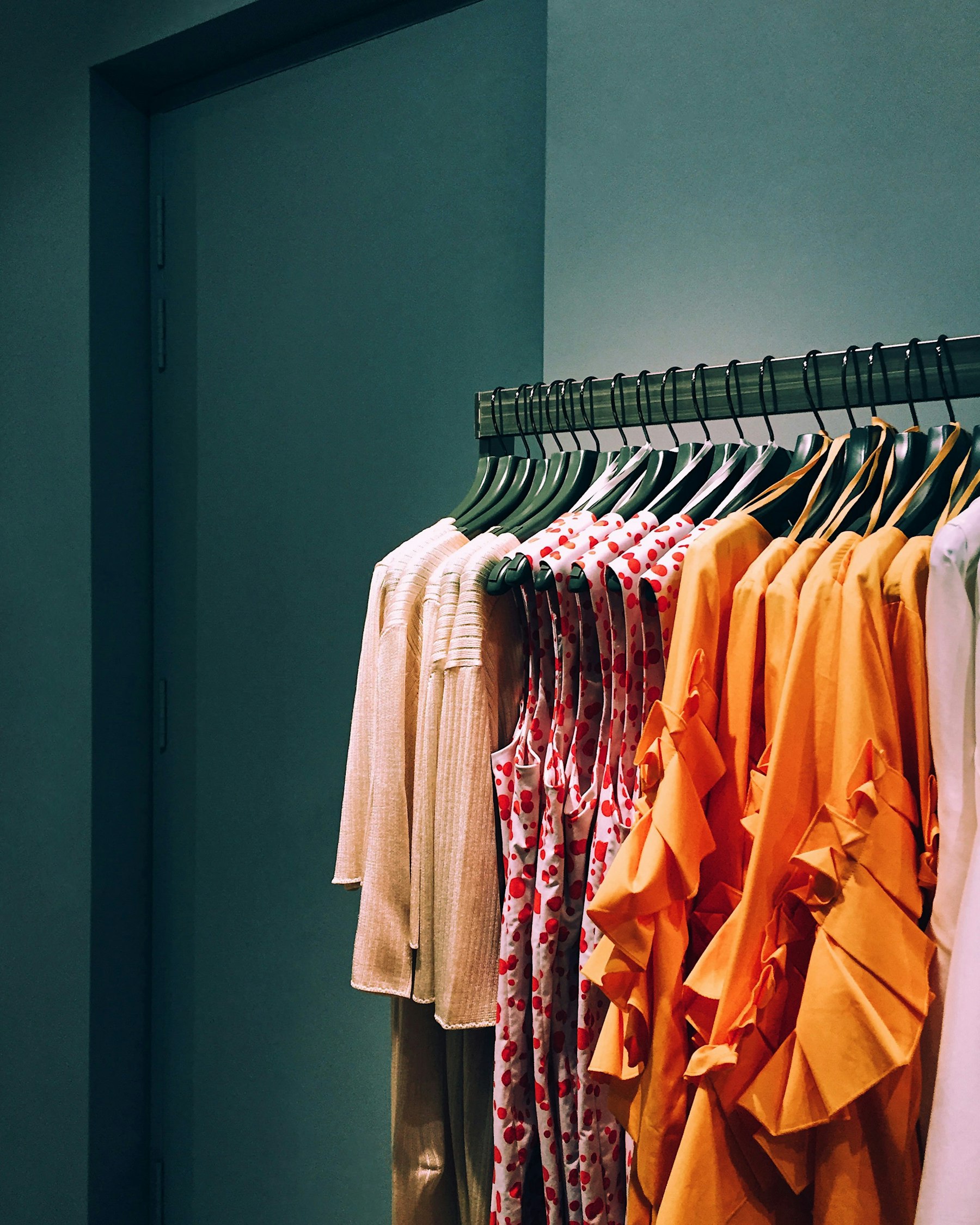 Assorted shirts and sweaters hanging on a clothing rack