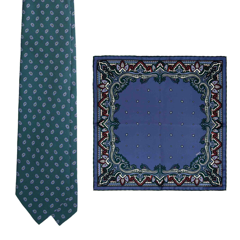 Green patterned silk tie beside a plum and blue patterned pocket square