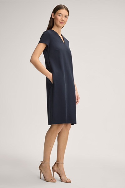 Model wearing a navy short-sleeved shift dress with heels
