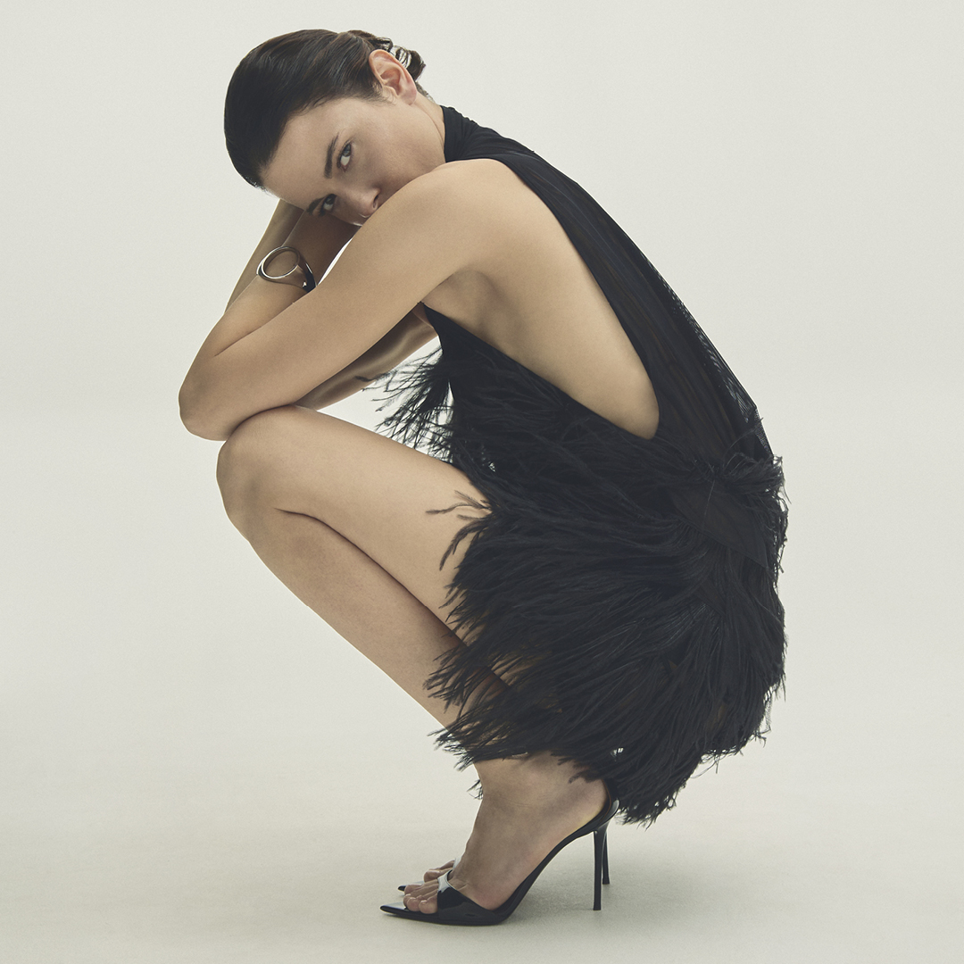 Fashion model poses in a black feather-trimmed dress for a Julian Fashion editorial