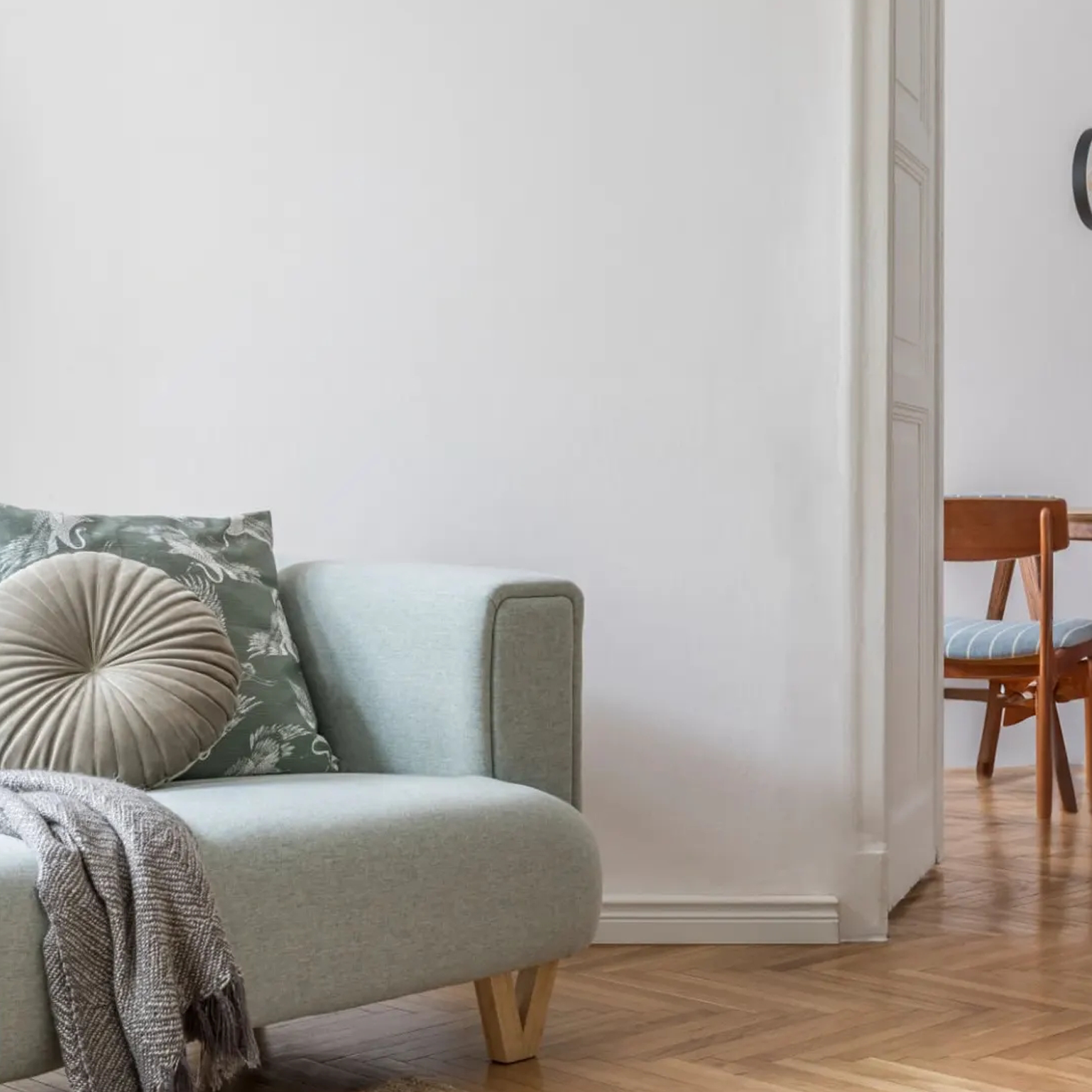 Bright living room with a pale green armchair beside a softly painted wall
