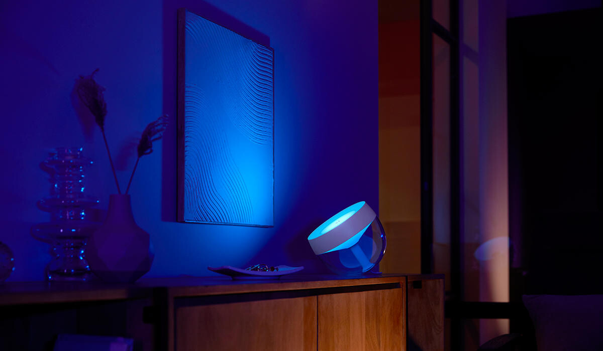 Philips Hue Iris lamp casting blue and purple light across a room