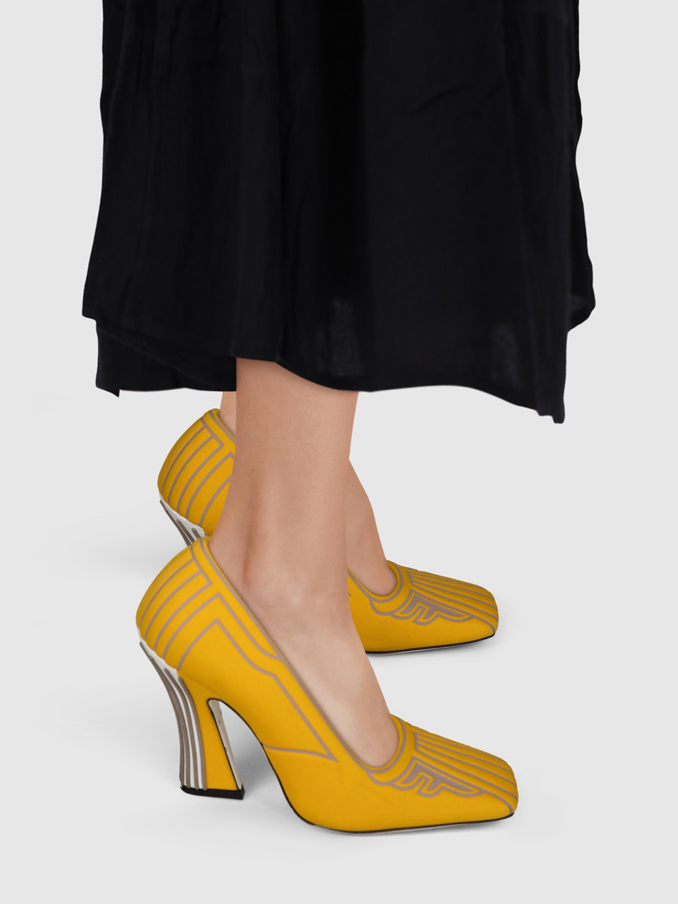 Yellow Fendi square-toe pumps with sculpted heels worn with a black dress