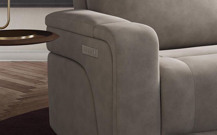 Close view of a grey upholstered Adstock reclining sofa in a living room