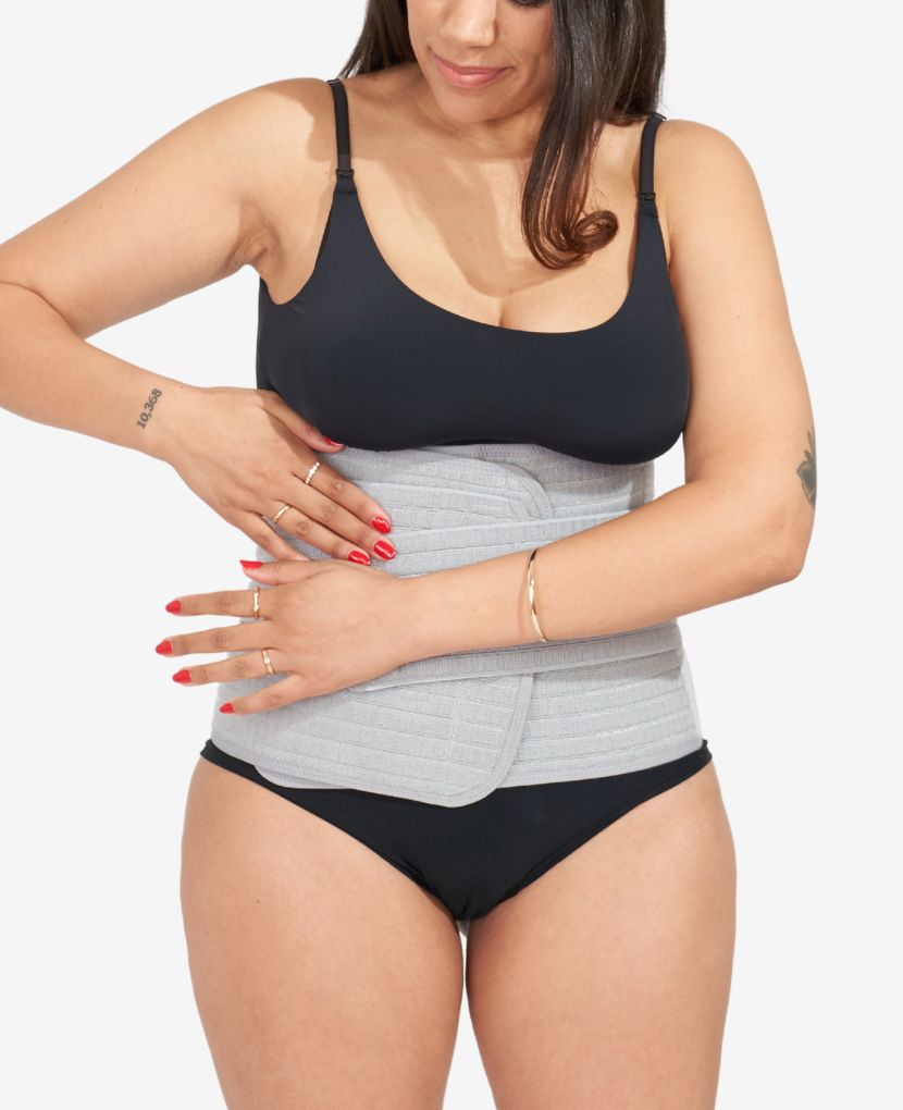 Woman adjusting a gray postpartum abdominal support band