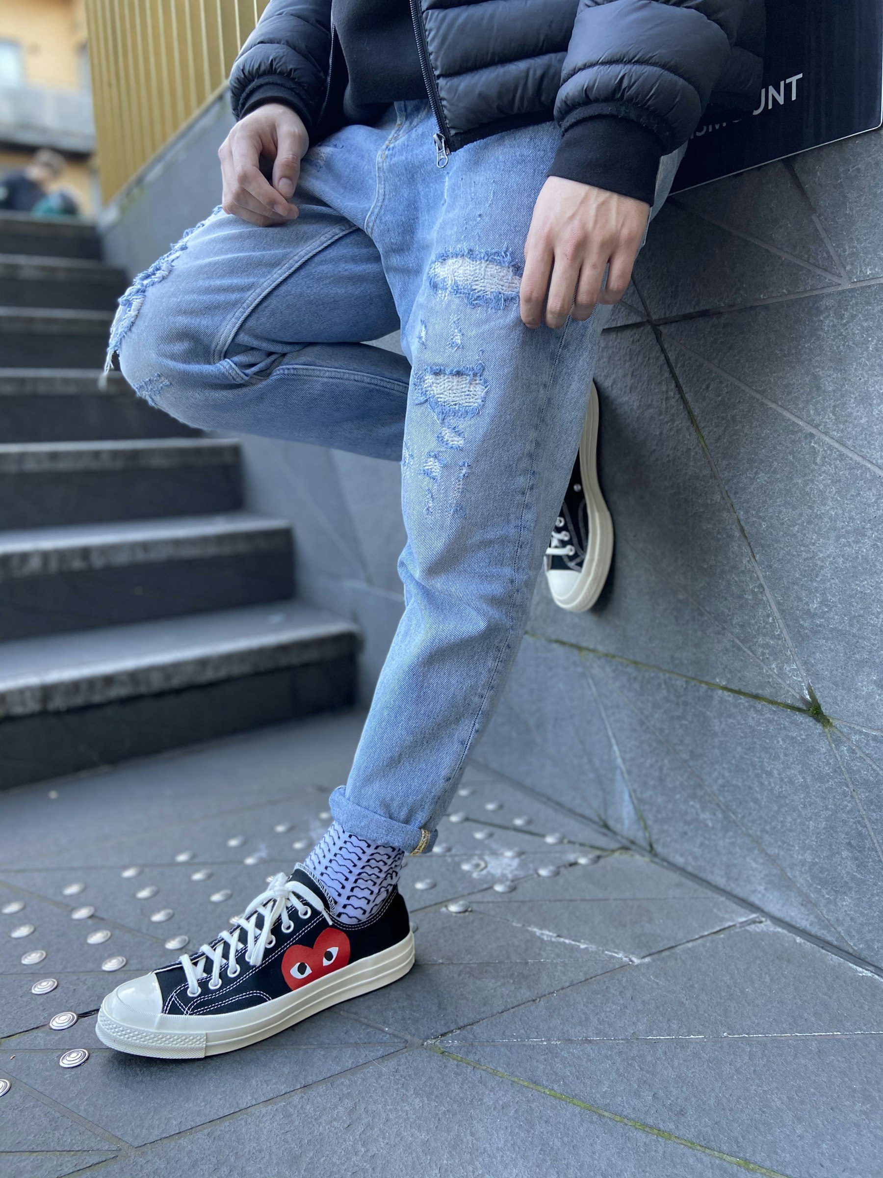 Person wearing blue denim jeans and casual sneakers