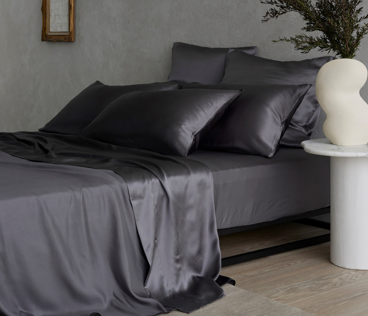 Bed dressed with dark grey mulberry silk sheets and pillows
