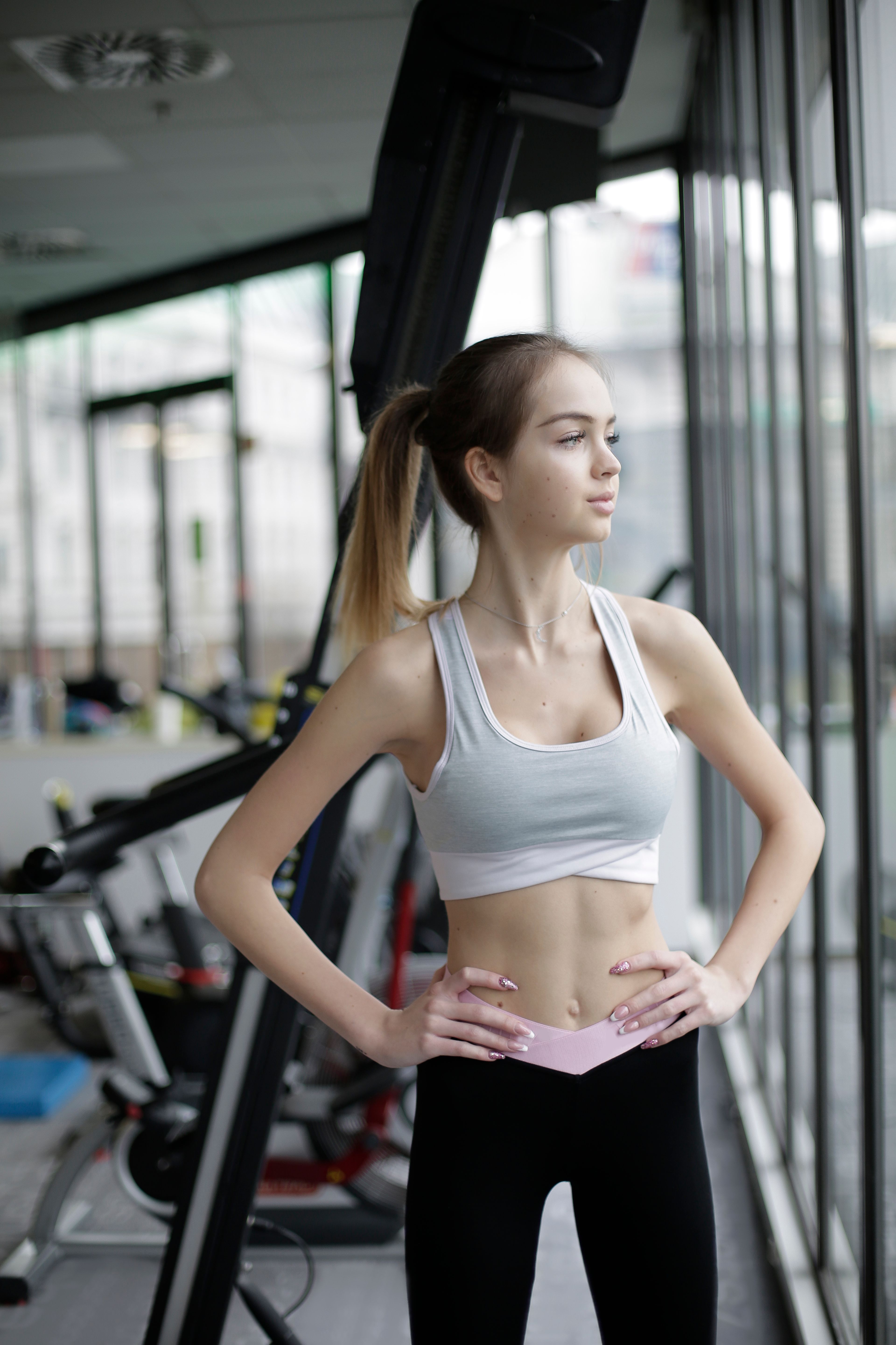 Woman in activewear standing beside exercise equipment in a gym