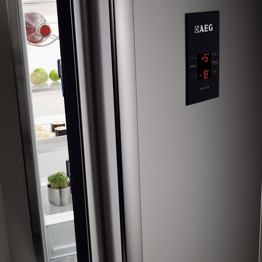 Stainless steel AEG refrigerator with one door open to show the interior shelves