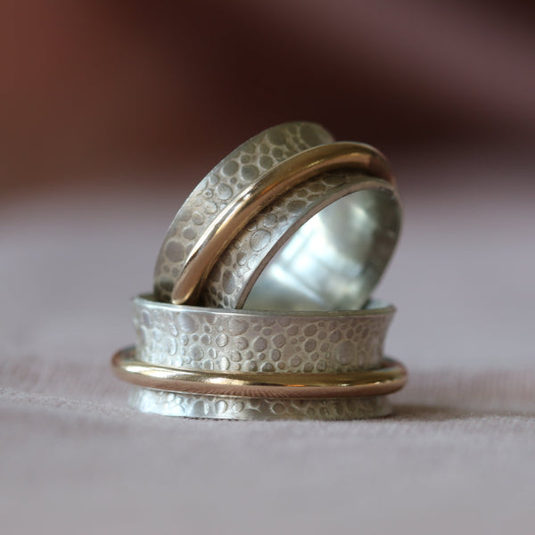 Stack of handcrafted textured silver and gold-tone rings
