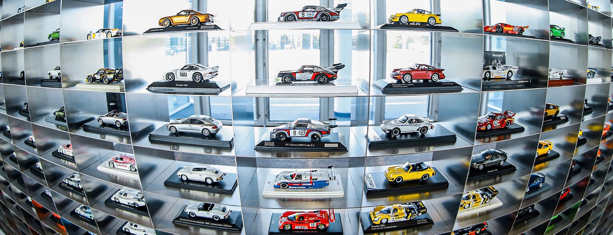Large collection of detailed Porsche scale-model cars arranged on display shelves