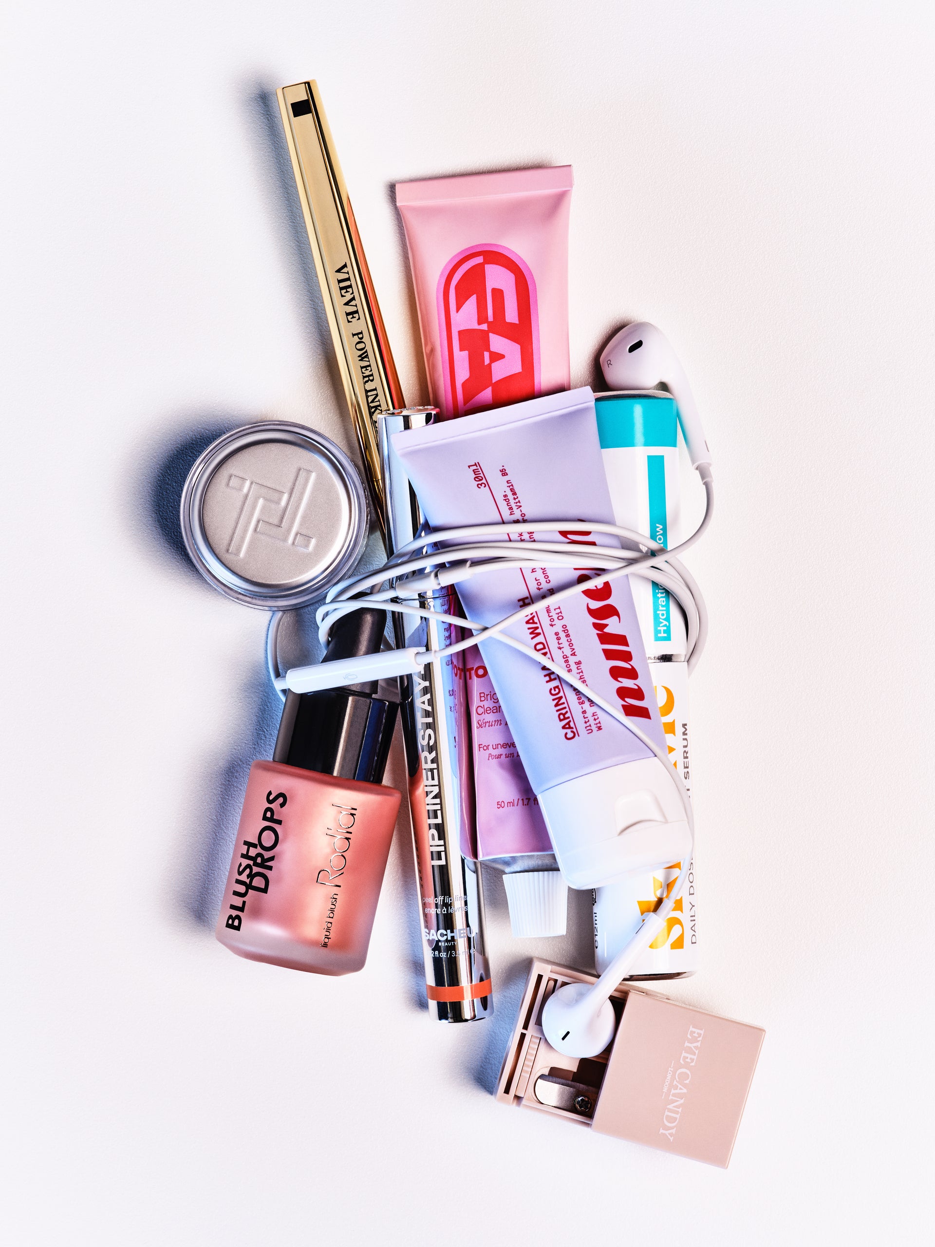 Assorted makeup and beauty products arranged together on a white surface