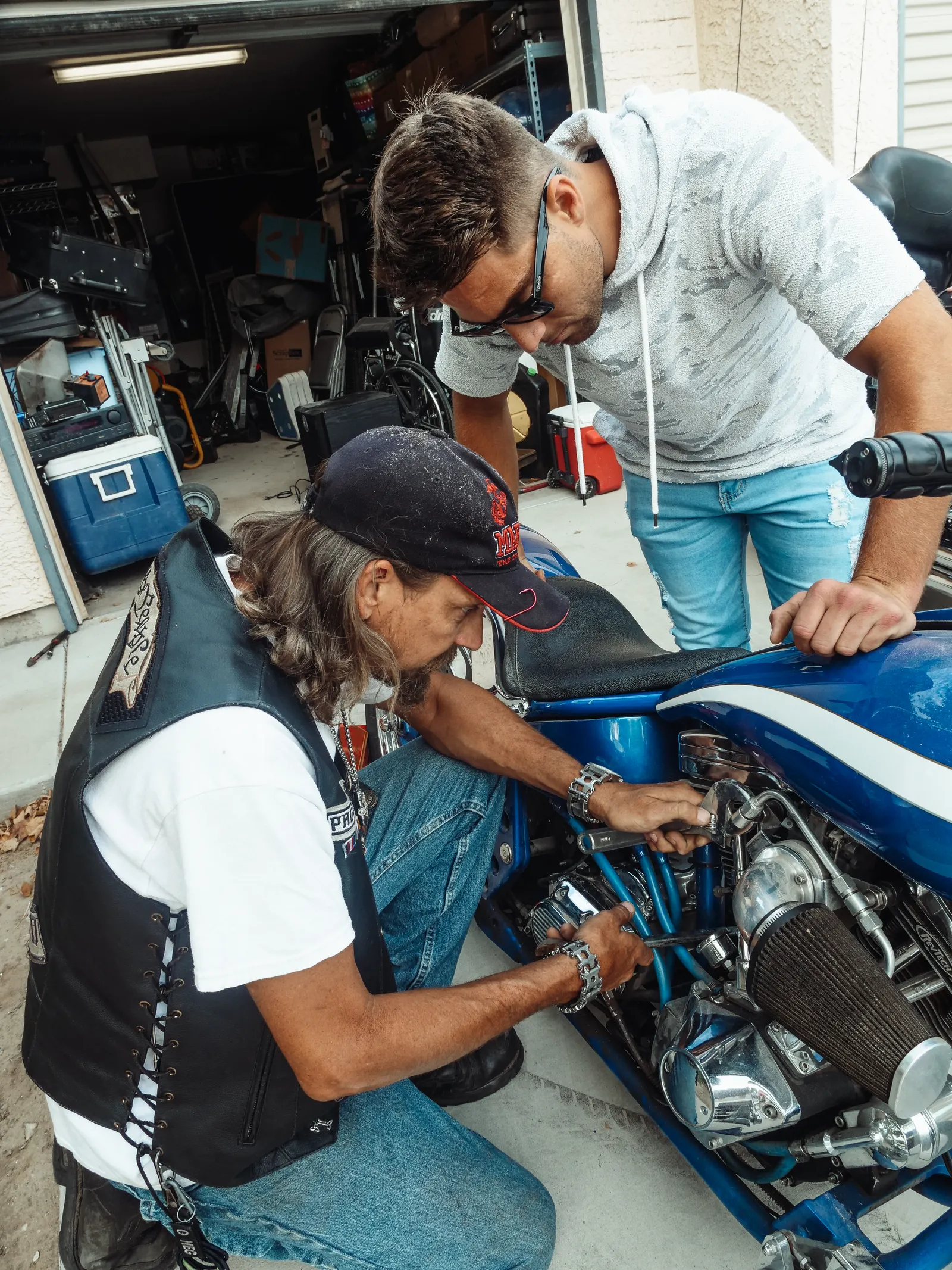 Father and son working on a motorcycle in a garage