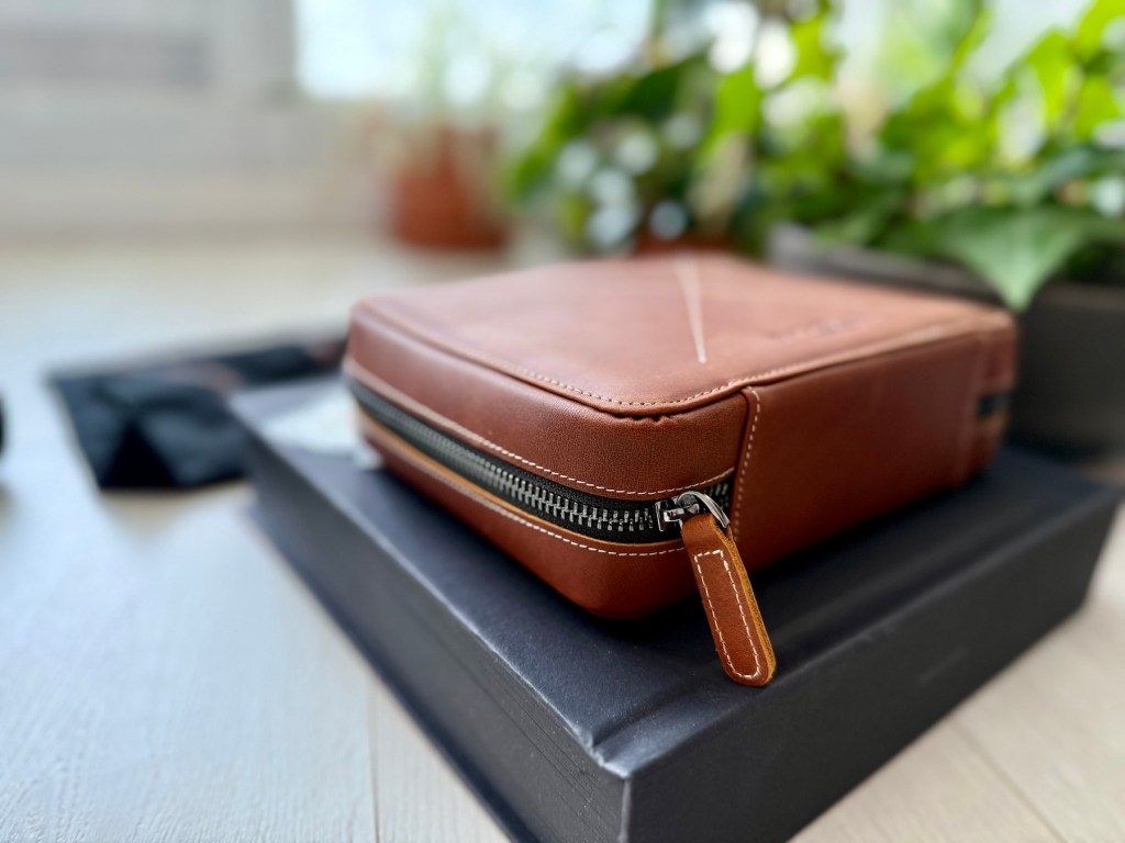 Brown leather zippered tech organizer resting on its presentation box