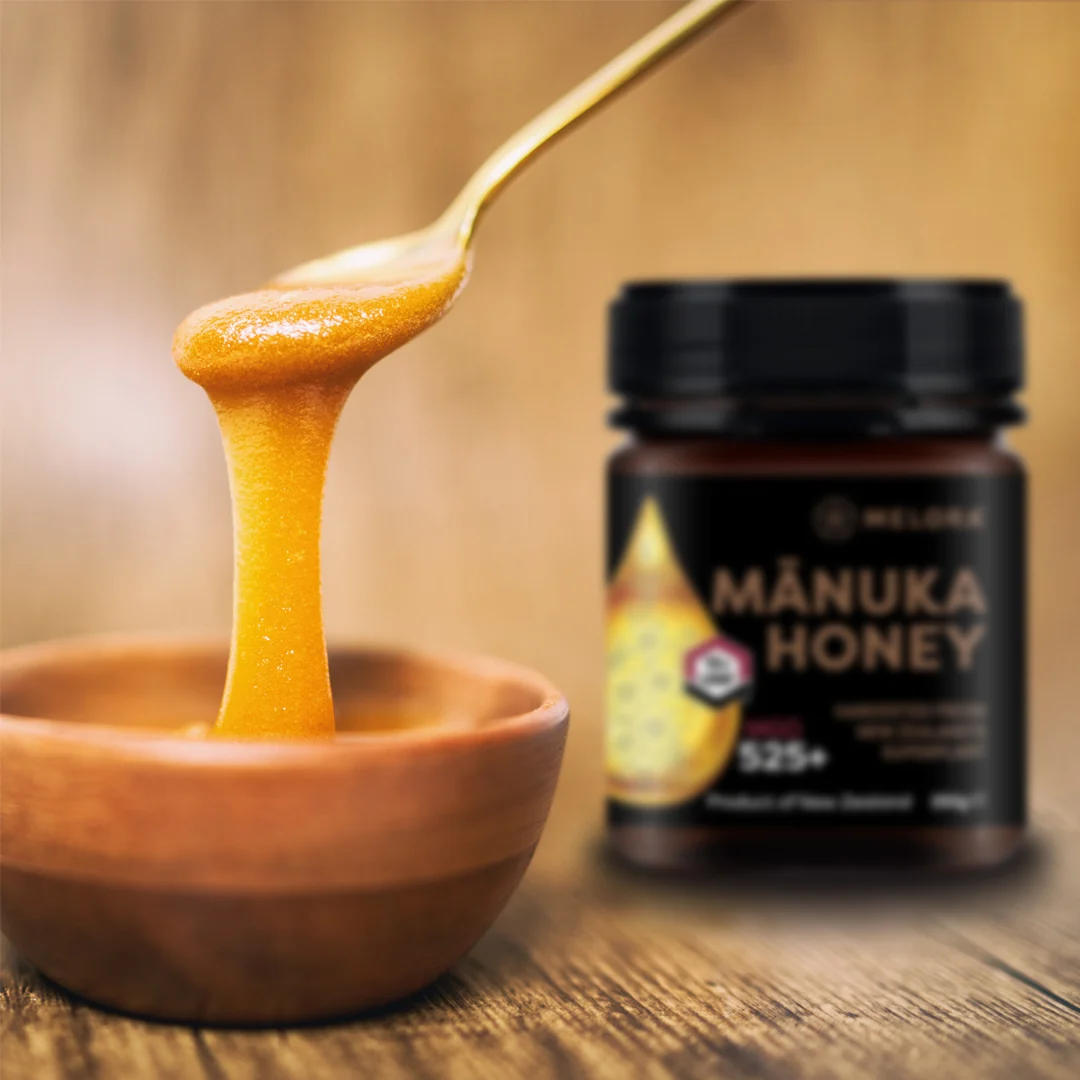 Melora MGO-rated mānuka honey beside a honey spoon