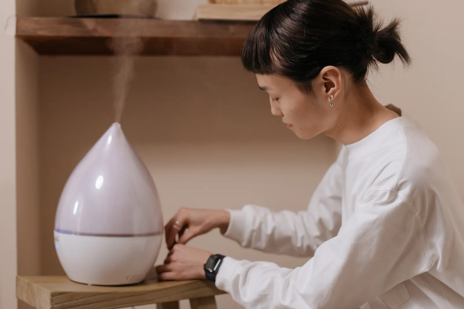 Woman adjusting a humidifier to improve indoor air quality