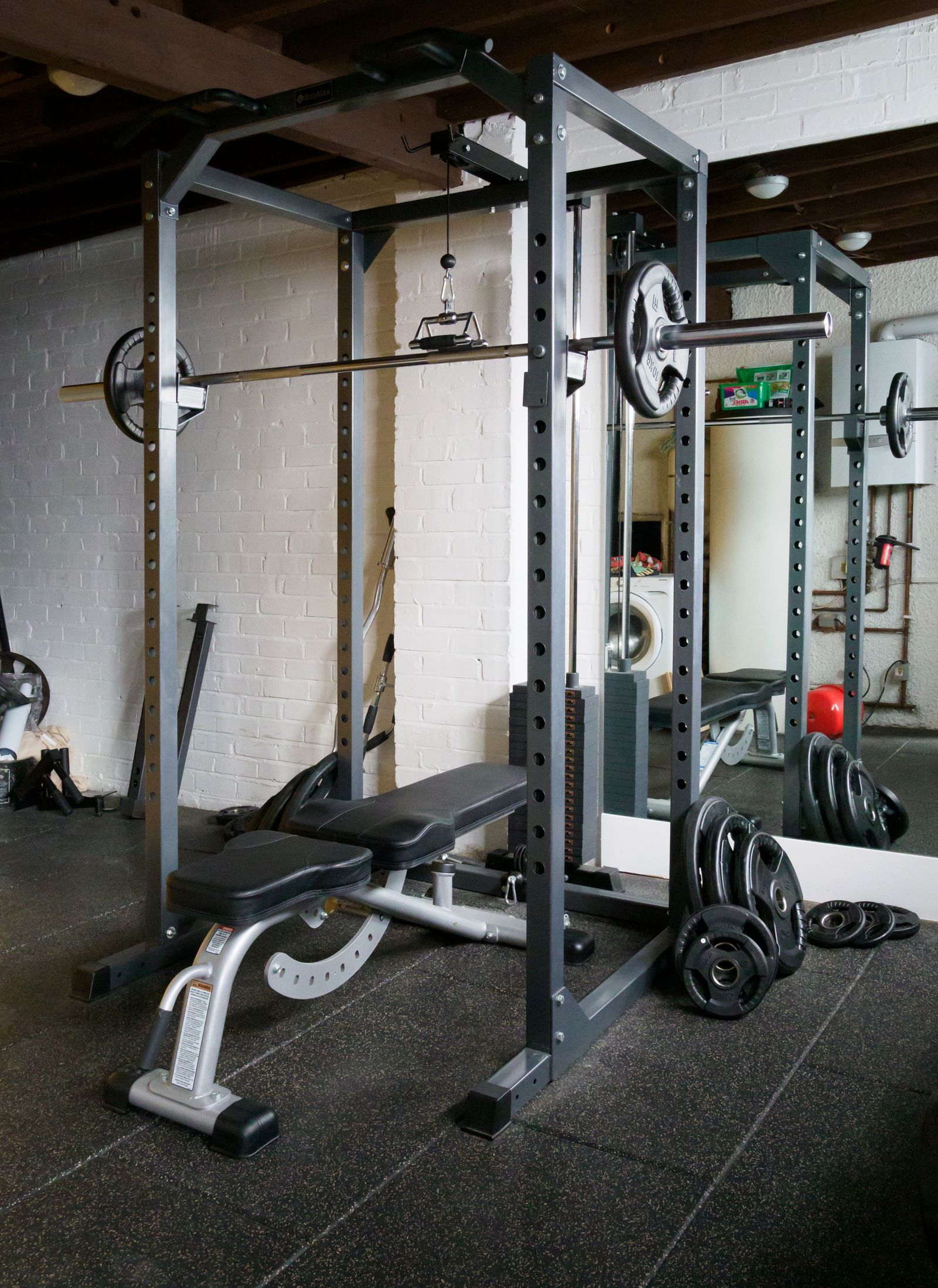Home gym with a cable weight machine, bench and barbell equipment
