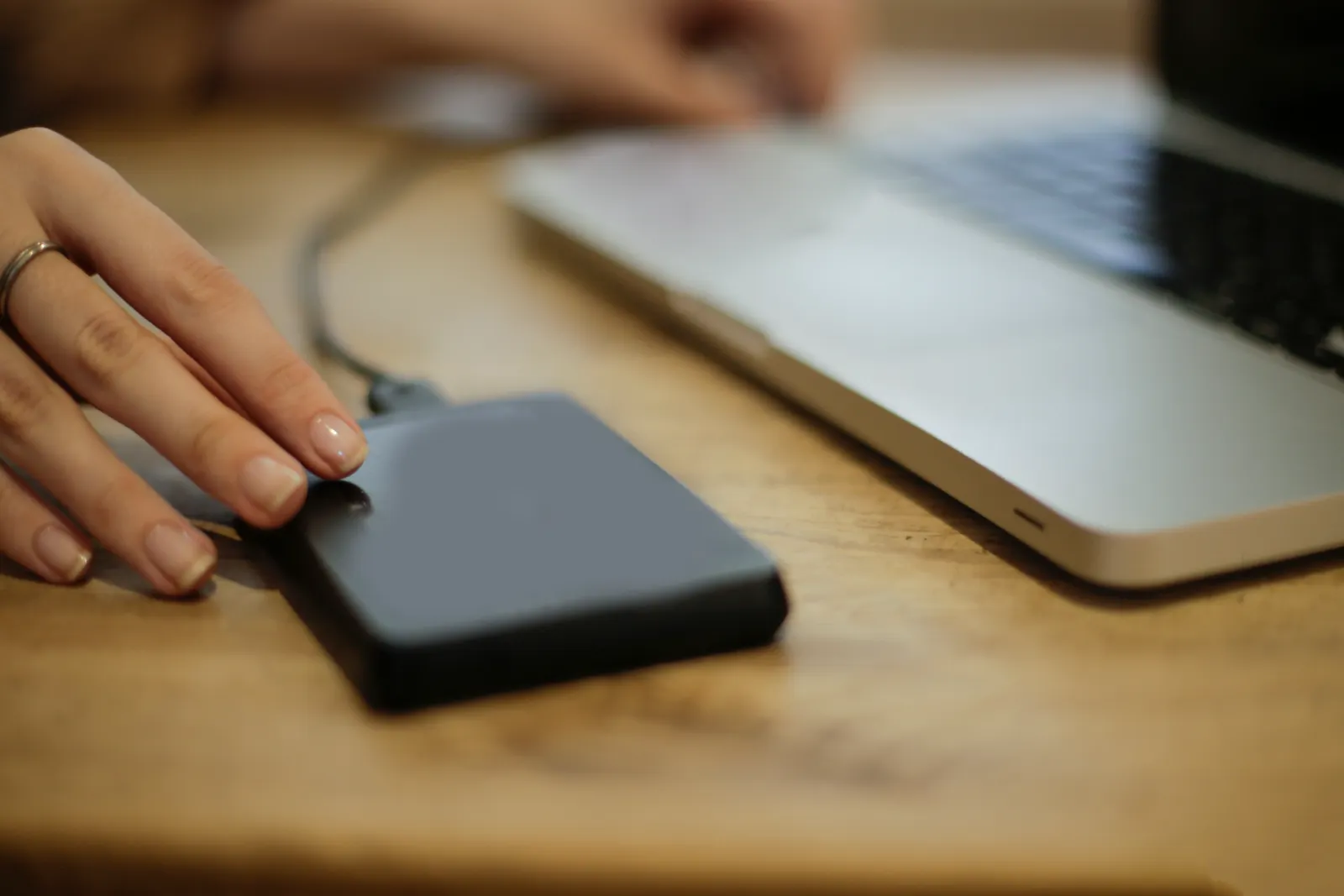 Person connecting an external hard drive to a laptop