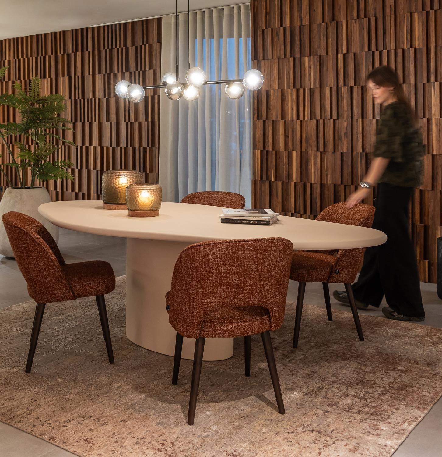 Contemporary dining room with an oval table, rust-coloured chairs and a globe pendant light