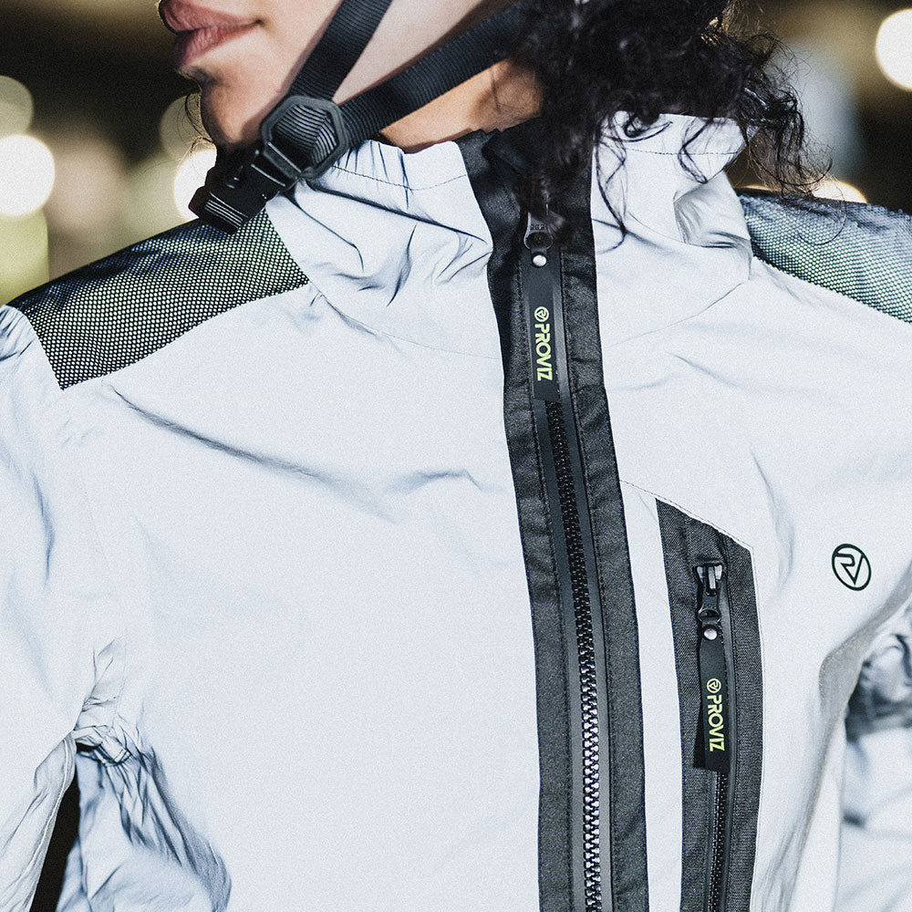 Cyclist fastening the high collar of a reflective Proviz jacket