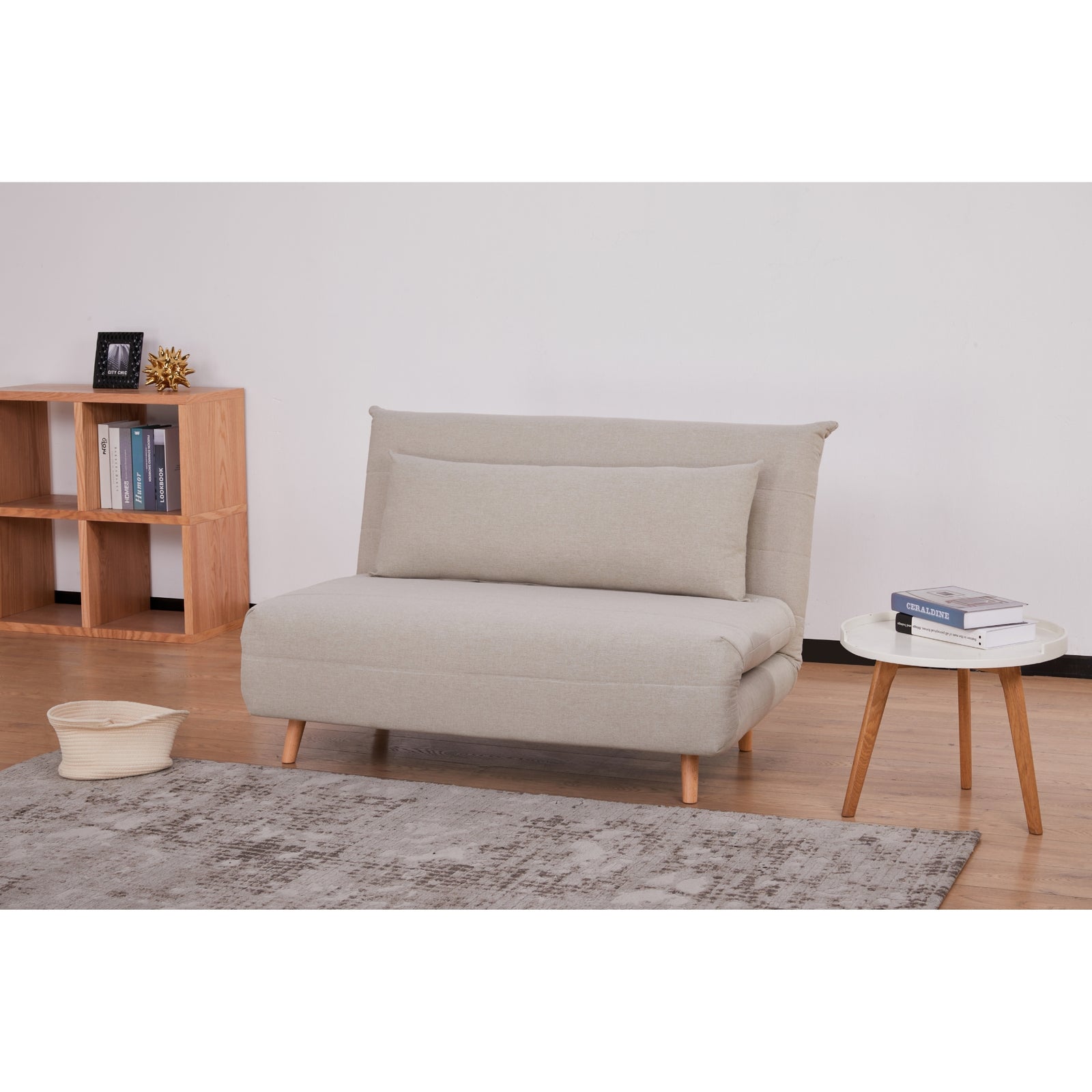 Compact beige two-seat sofa bed staged in a living room with wooden side tables