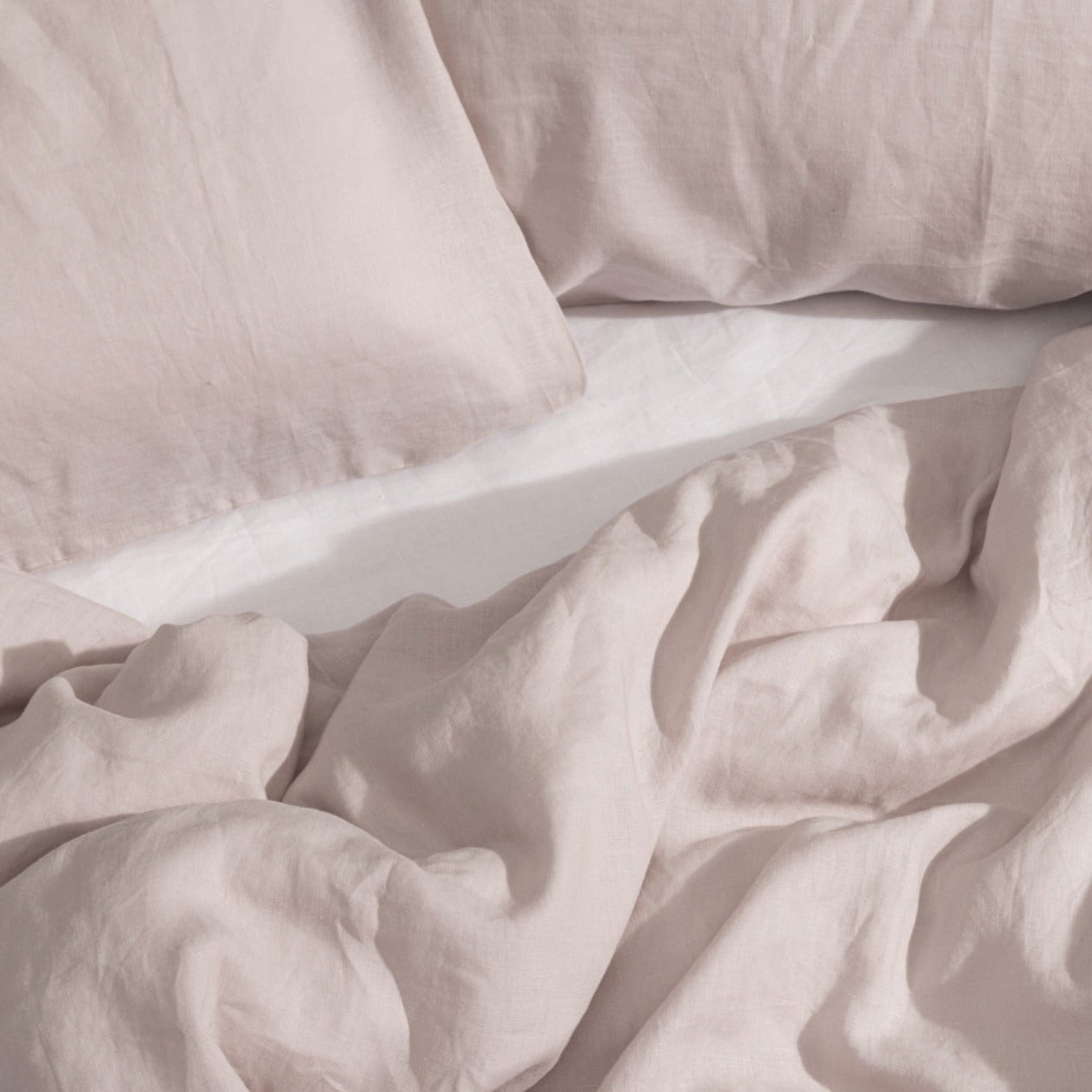 Blush linen pillows and rumpled bed linen from Cuddledown