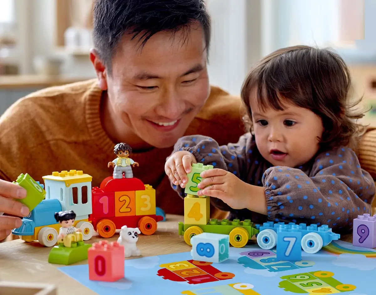 Adult and child playing with age-appropriate building toys at The Entertainer