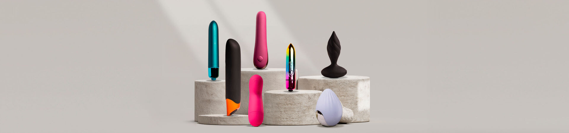 Colourful personal massagers arranged upright on neutral display blocks