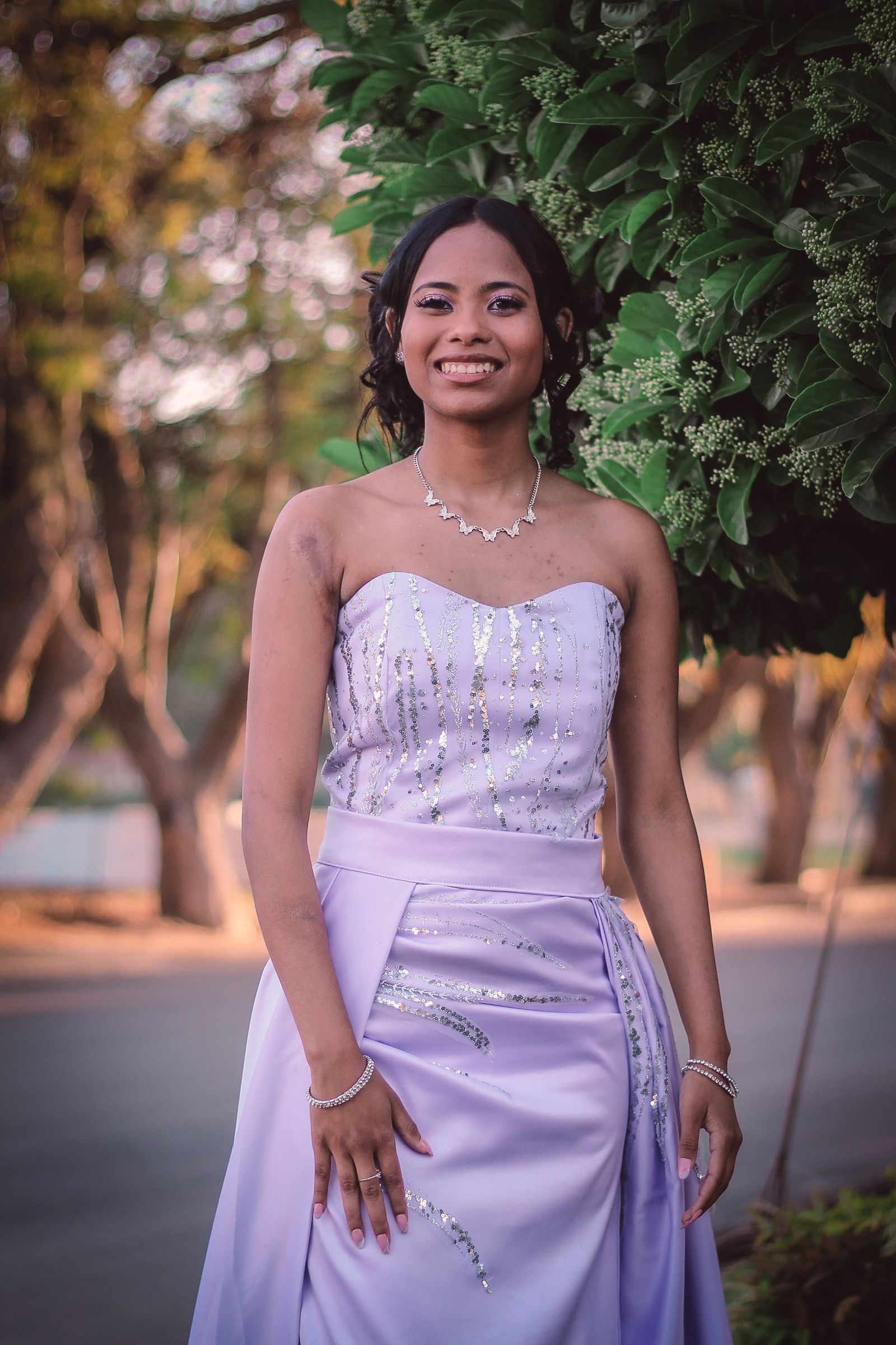 Woman wearing a pale purple formal gown outdoors
