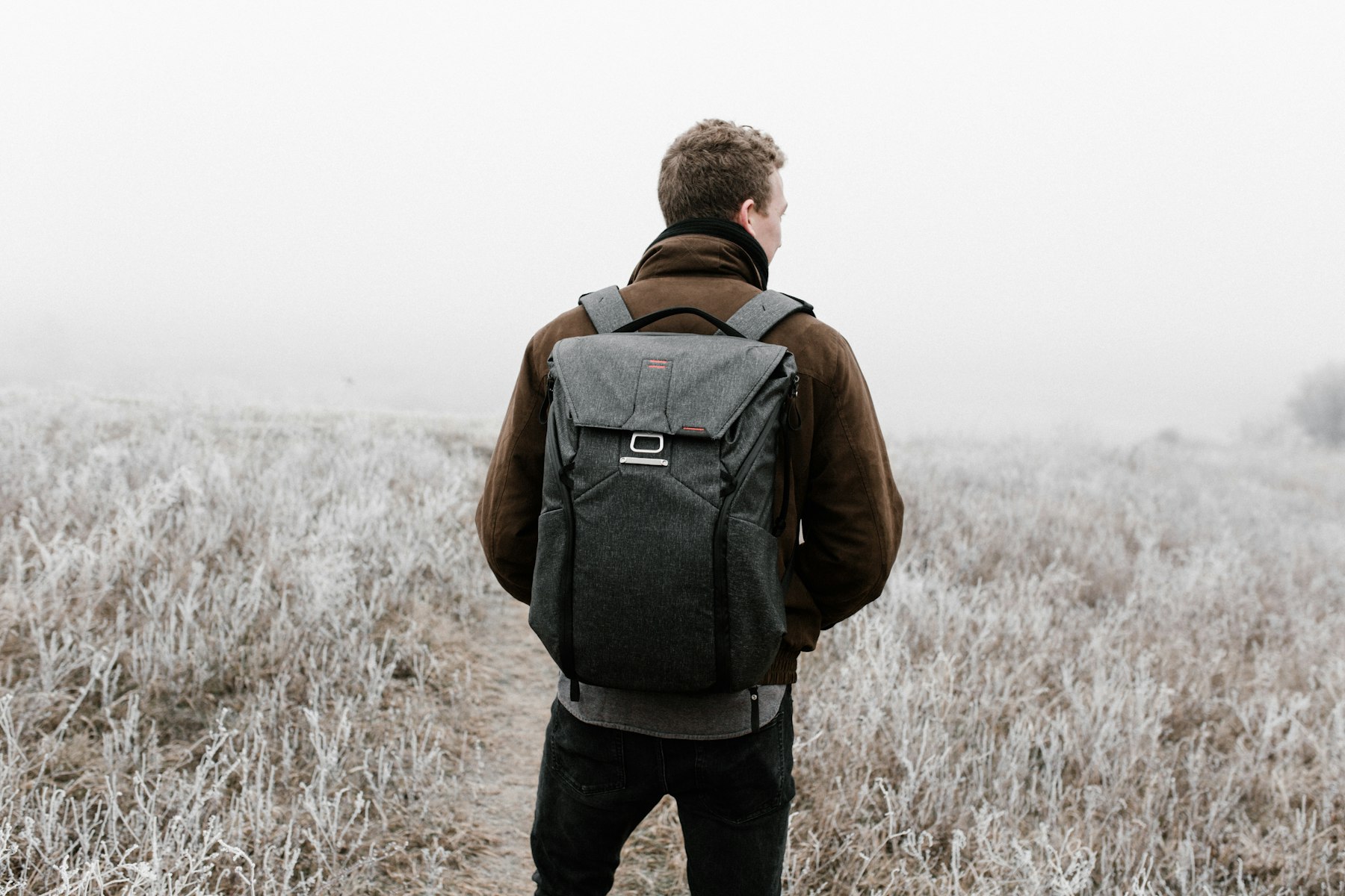 Traveller wearing a backpack on a misty outdoor path