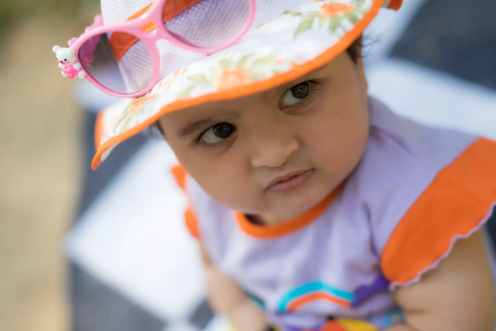 Baby wearing a colorful sun hat outdoors