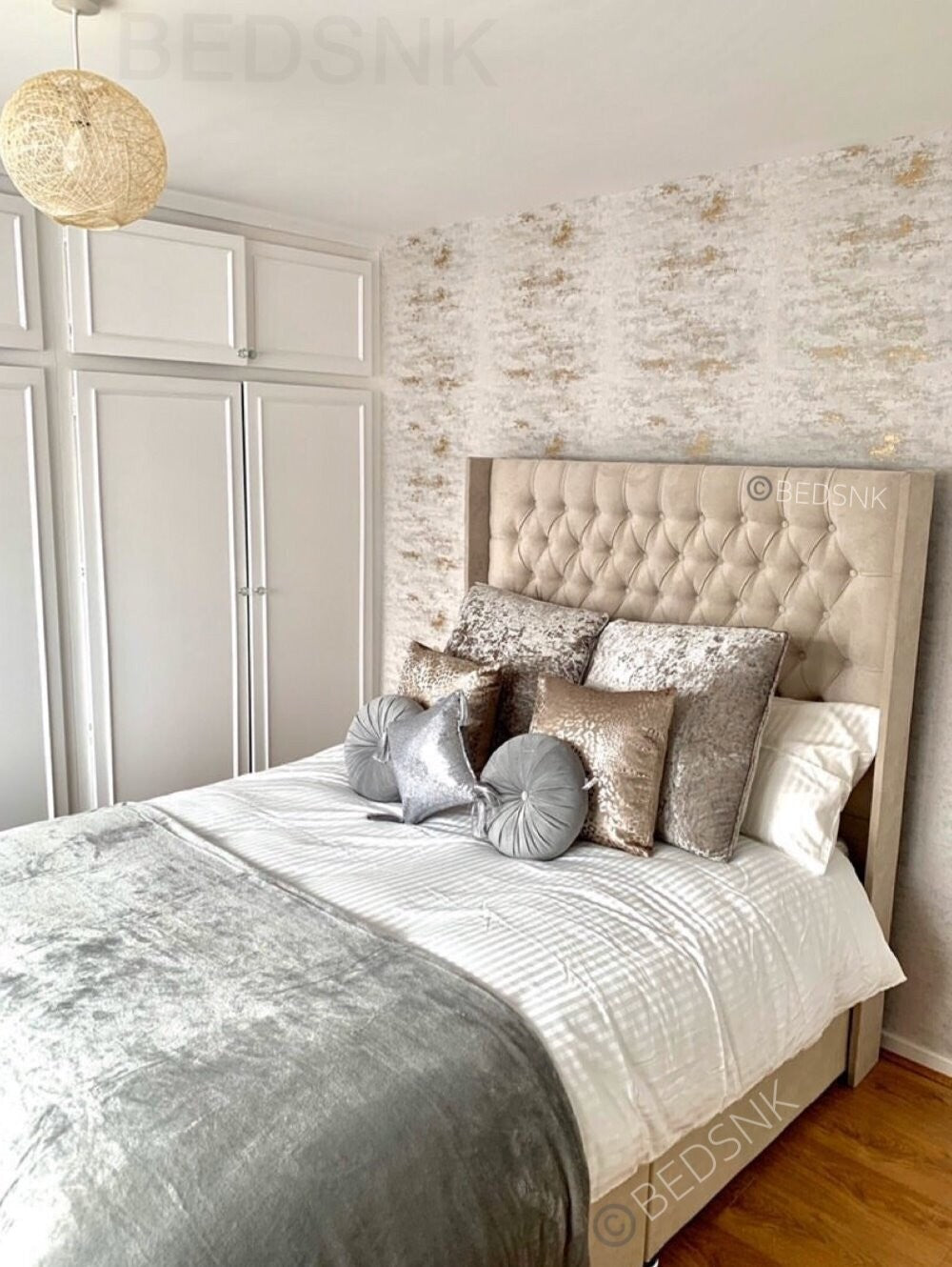 Upholstered bed with a tall winged headboard in a decorated bedroom