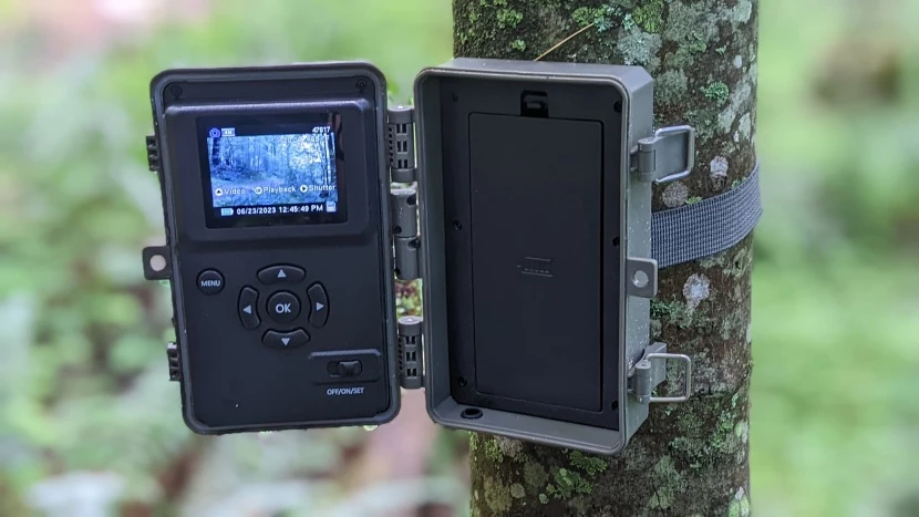 Open GardePro trail camera strapped to a tree with its rear screen visible