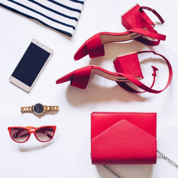 Flat lay of sunglasses, watch, sandals, clutch, and phone