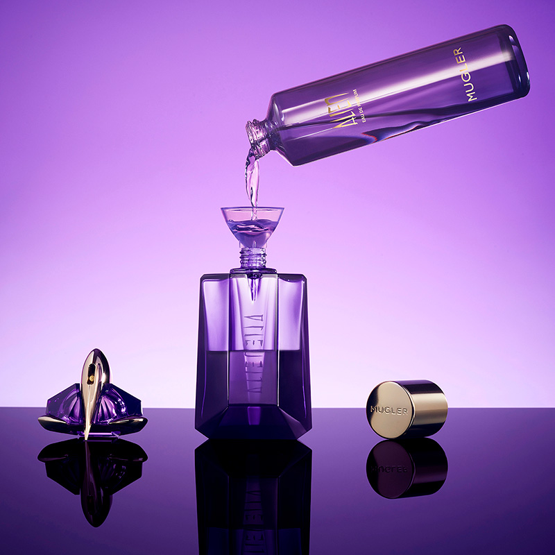 Purple perfume bottles and caps arranged under studio lighting