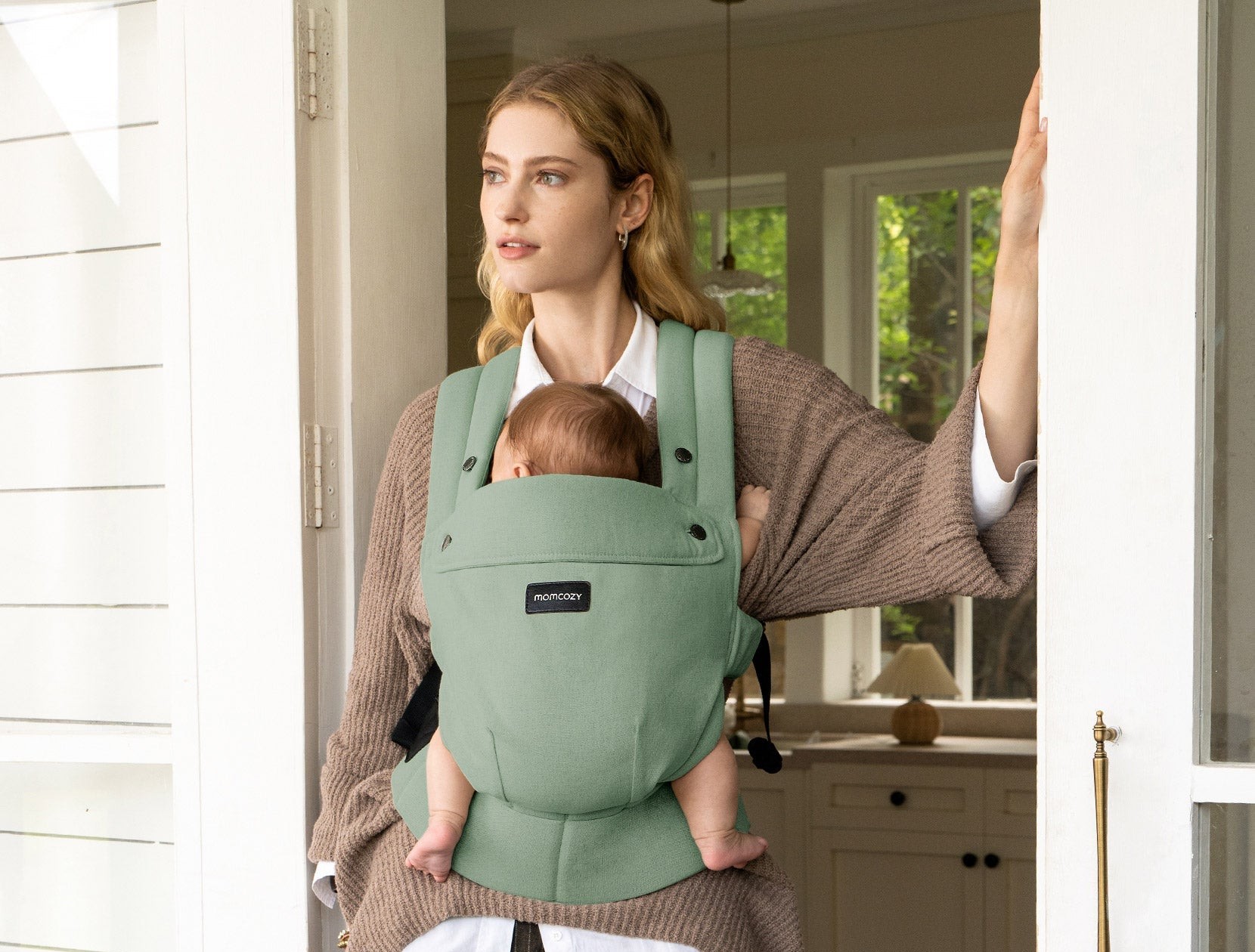 Parent carrying a baby with a Momcozy carrier