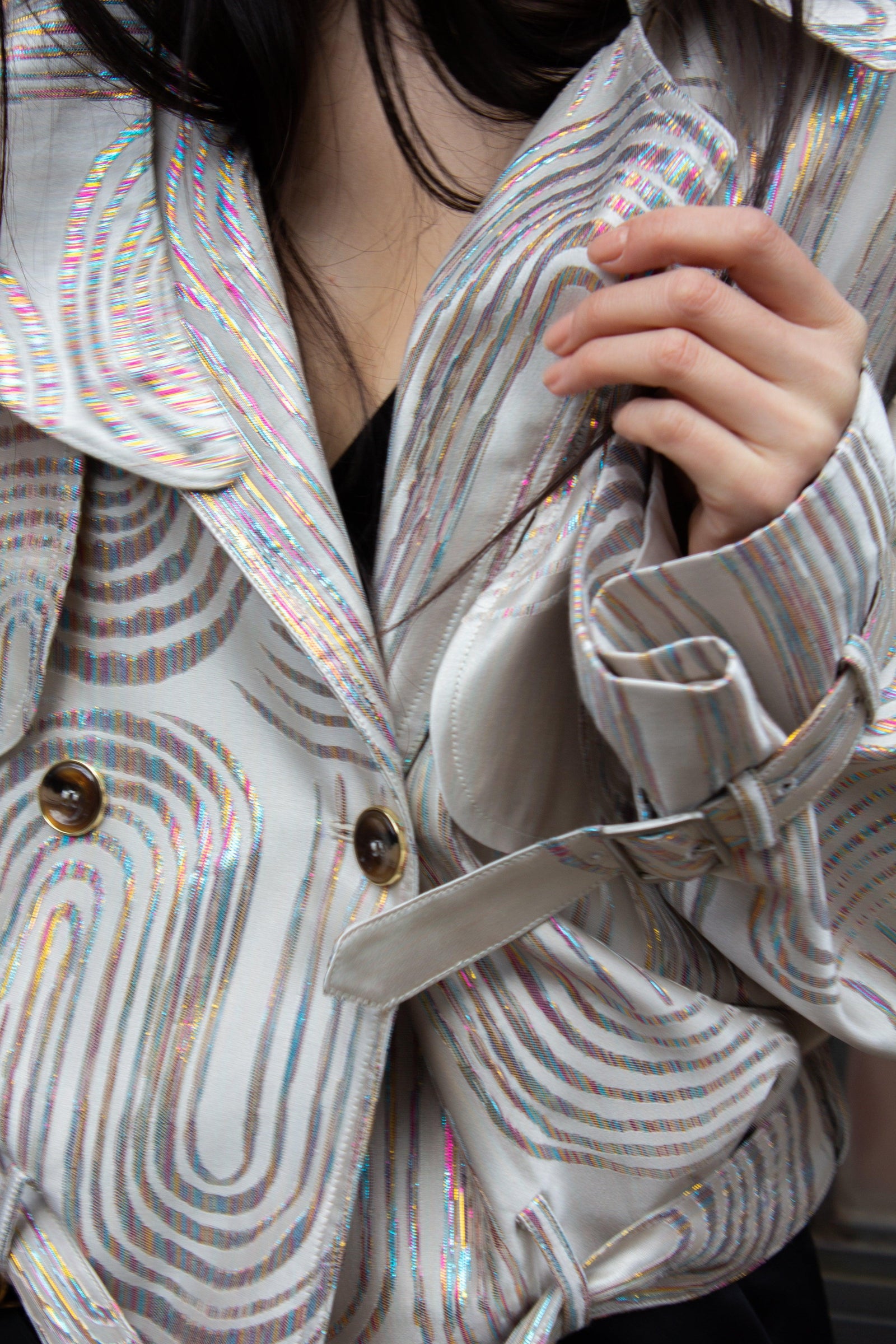 Model wearing a pale striped Le Réussi jacket with an iridescent collar