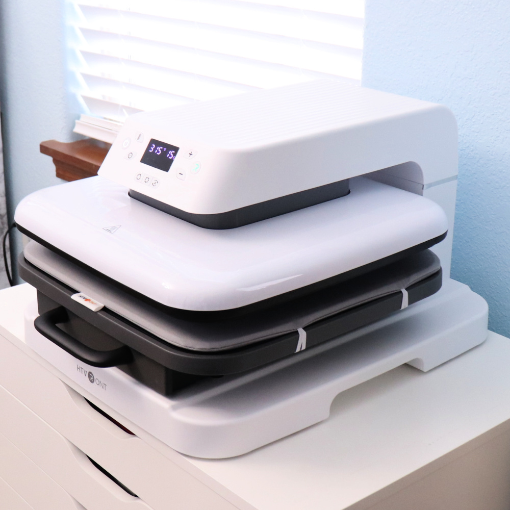 White HTVRONT automatic heat press set up in a craft room