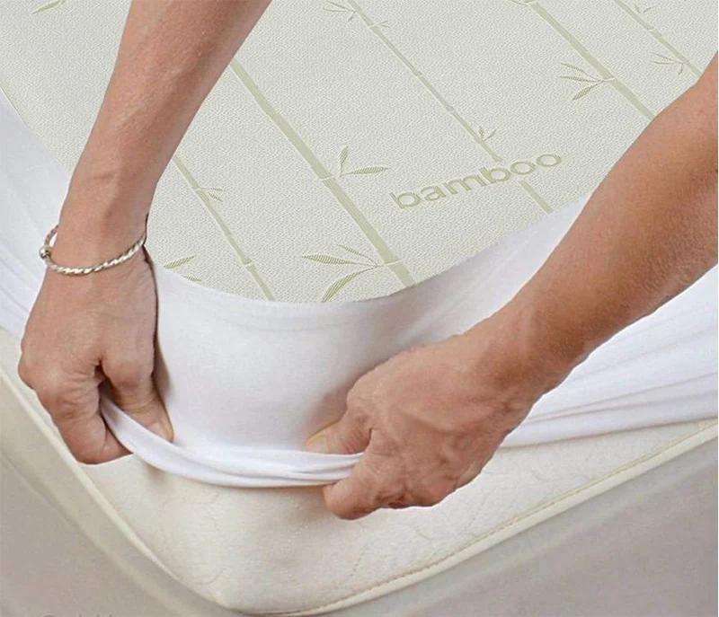 Hypoallergenic bamboo mattress protector being fitted to a bed