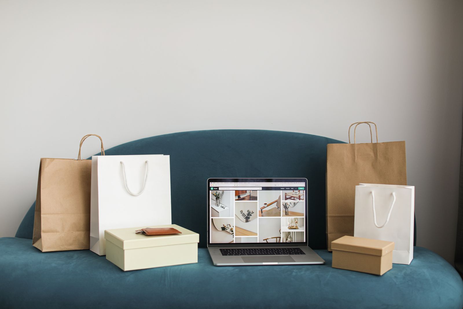 Laptop surrounded by shopping bags and delivery boxes