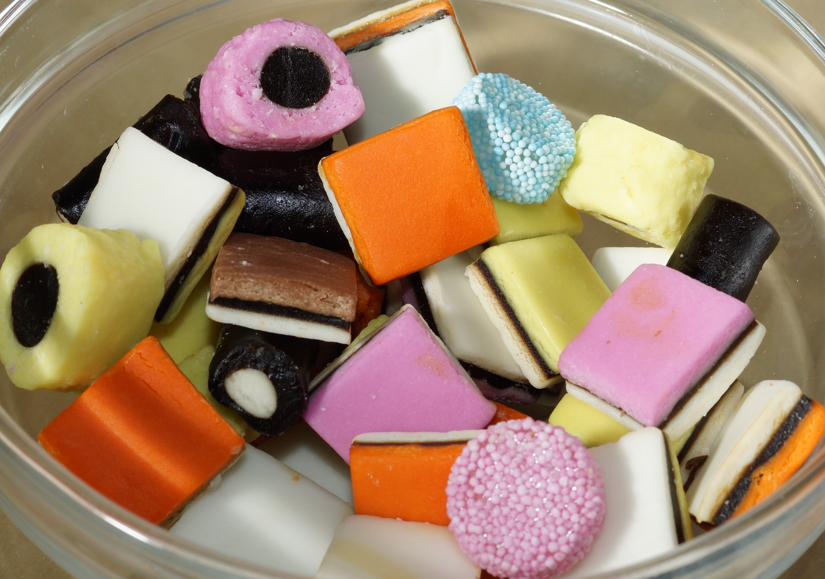 Colourful liquorice allsorts piled in a clear glass bowl